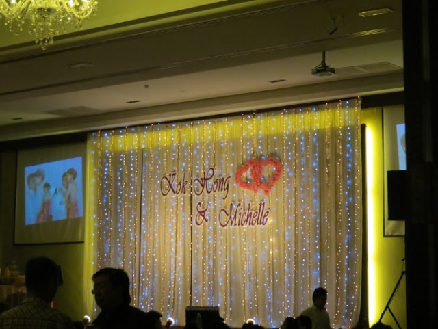 stage decorated with fairy lights, names of couple